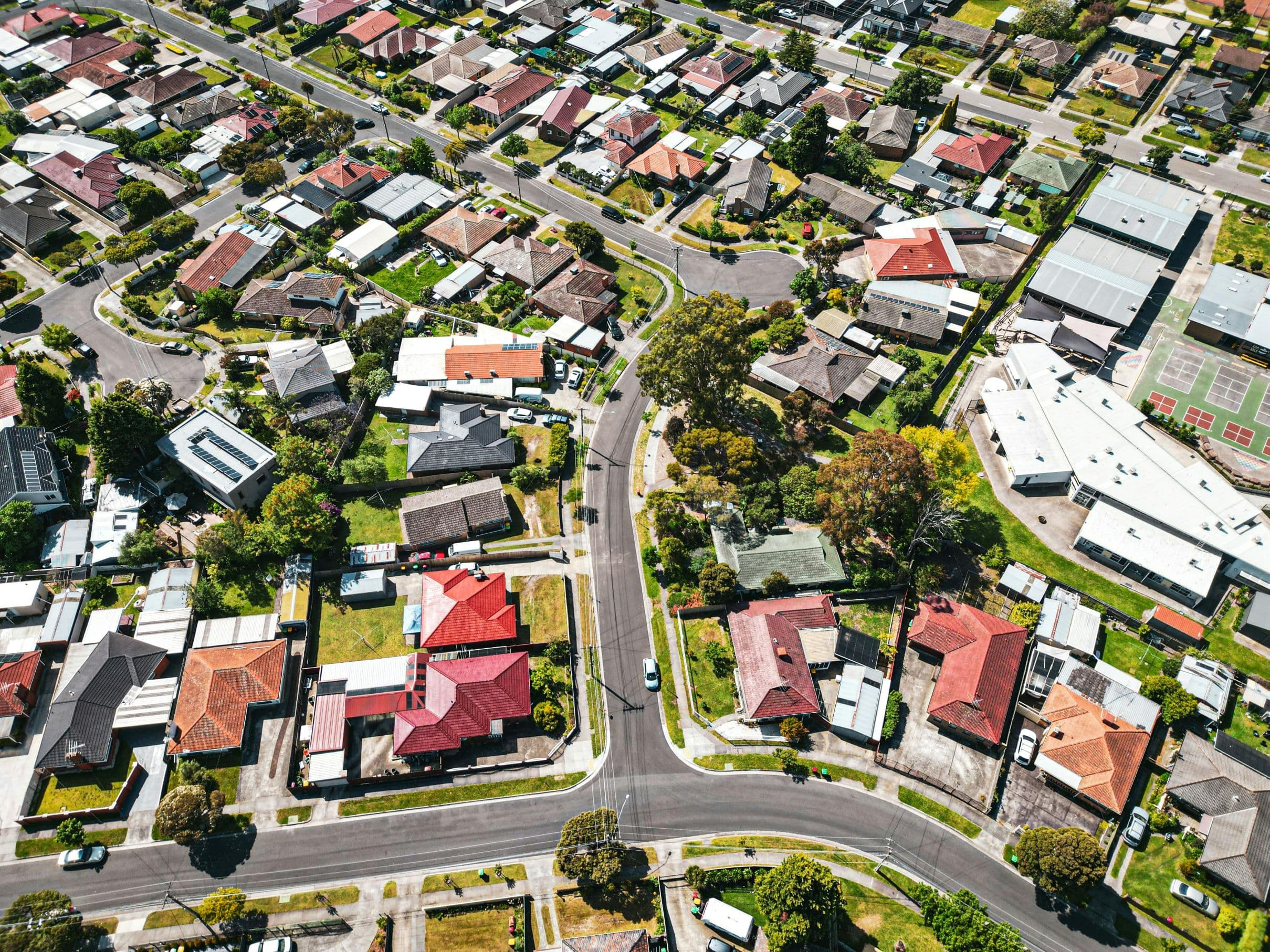 An aerial view of an Australian residential suburb showing detached houses, townhouses and a small apartment block sitting next to each other across visible zoning boundaries