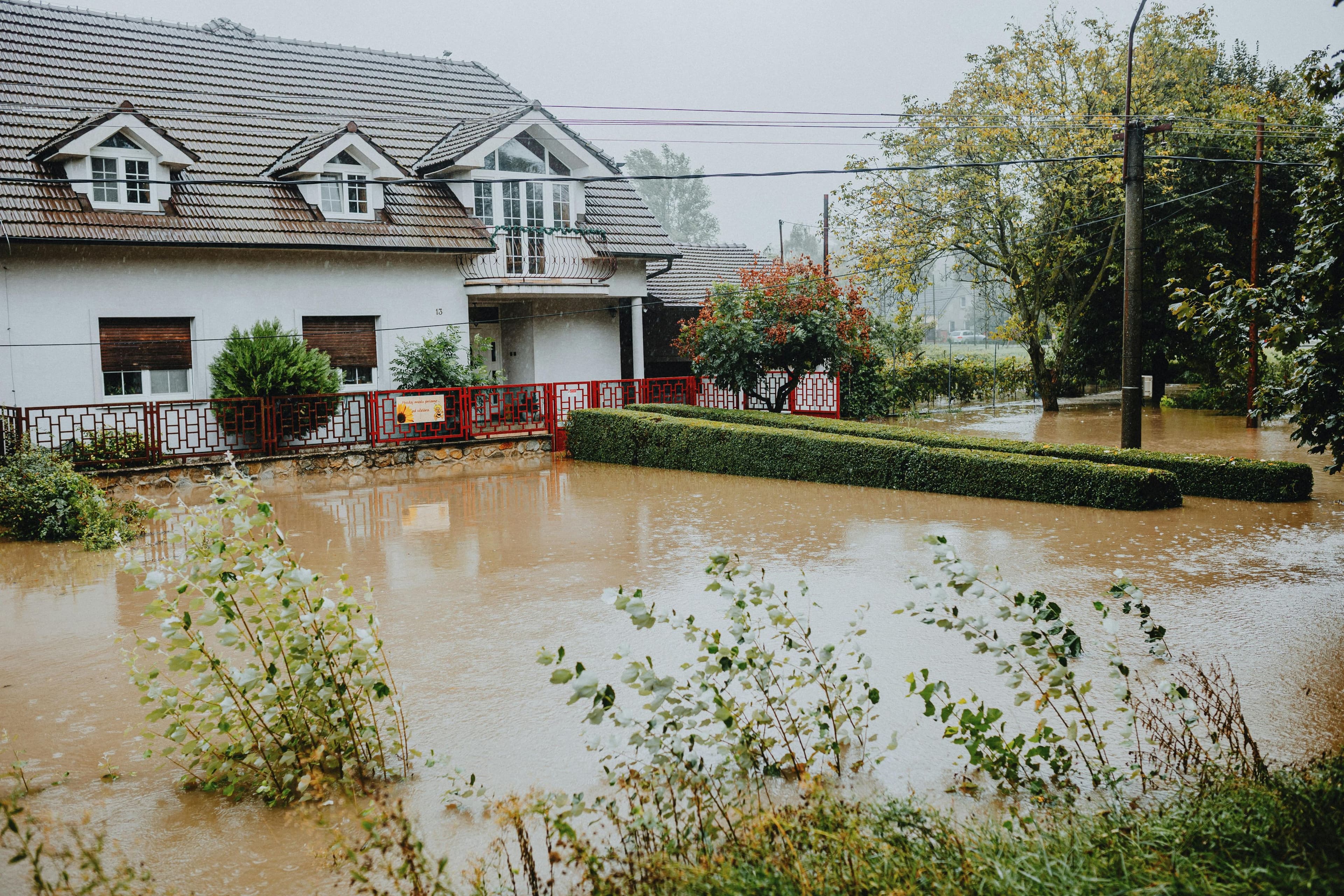 Aerial view of an Australian residential street partly submerged after heavy rainfall, with rooftops visible above the floodwater
